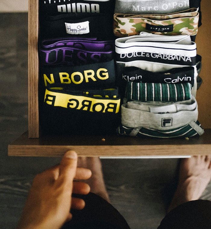 Closet drawer filled with folded men’s underwear brands, illustrating weird and adorable relationship truths about men.