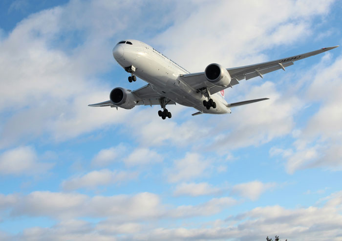 Commercial airplane flying low against a cloudy sky illustrating shocking corporate secrets customers never knew.