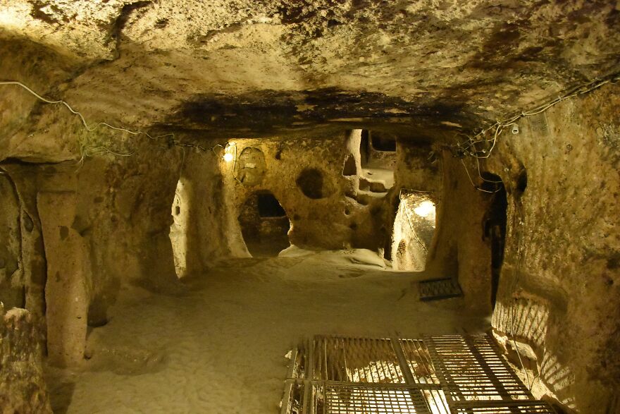 Underground cities carved in rock, showing tunnels and chambers with dim lighting and ventilation openings.