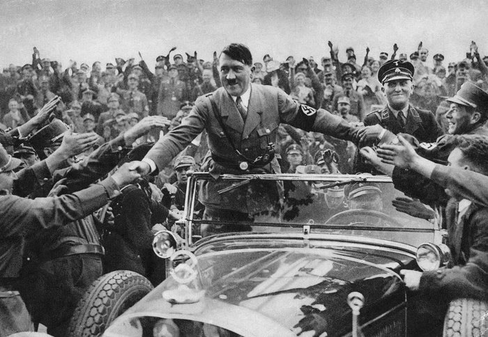 Adolf Hitler greeting supporters from a car, an infamous image of a famous leader who changed history.