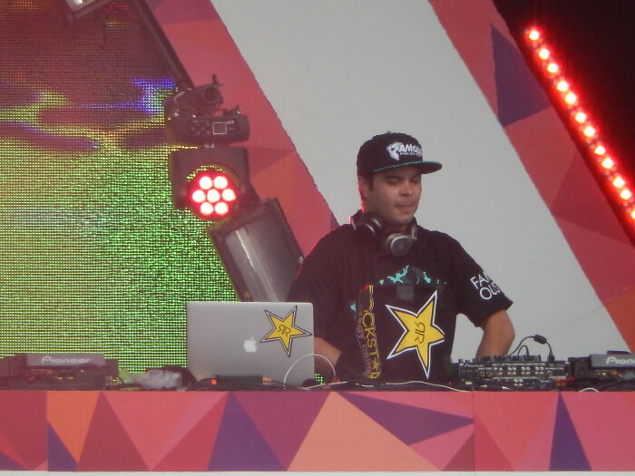 DJ performing live at an event with headphones and a laptop, capturing moments related to celebrities people used to like.