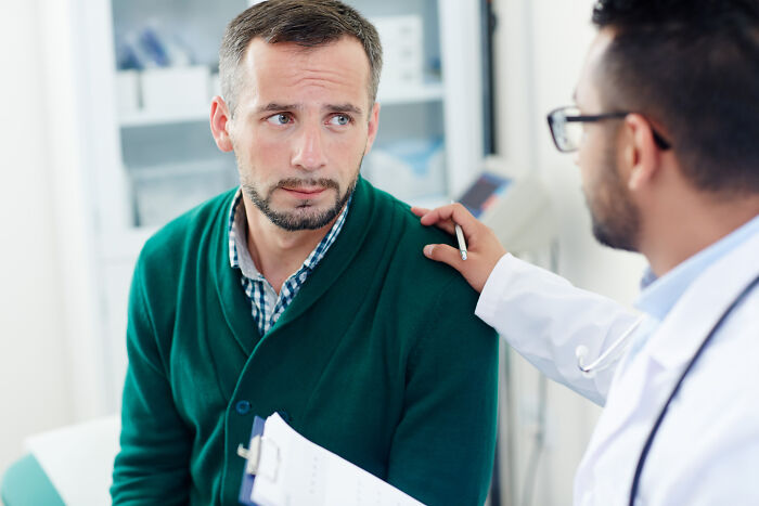 Doctor comforting a worried patient during a consultation, discussing medical concerns and test sample issues.
