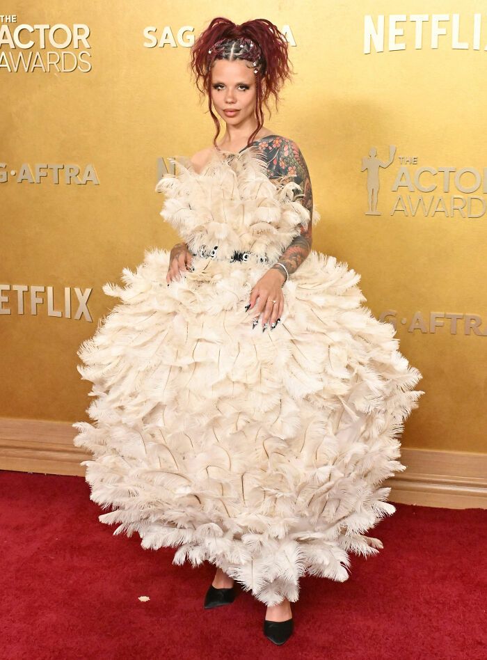 Celebrity wearing an extravagant feather dress at the Actor Awards amid sheer dress fatigue and worst dressed stars trend.
