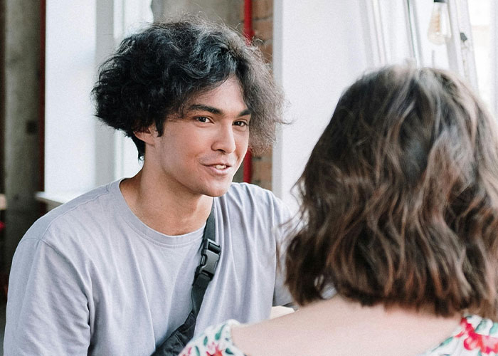 Young man and woman talking indoors, capturing the moment an ex reveals their true self during a divorce conversation.