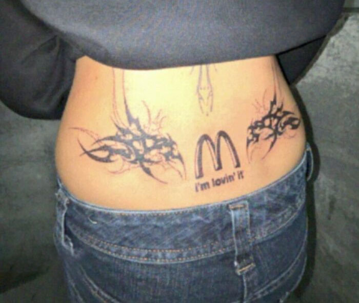 Lower back tattoo fail featuring a poorly executed McDonald's logo as part of ink fails and regrets.