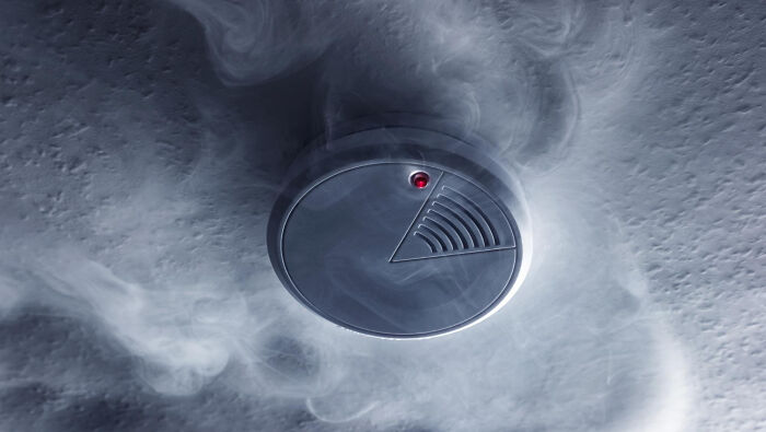 Smoke detector on ceiling surrounded by smoke illustrating bizarre encounters that left people questioning what they saw.