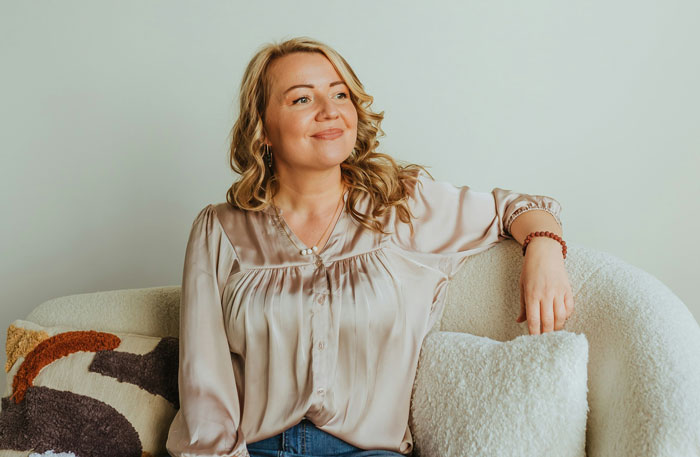 Mulher sentada em um sofá com ar pensativo, representando temas de teste de paternidade secreto e perguntas sobre bebês recém-nascidos. Mulher sentada em um sofá com ar pensativo, representando temas de teste de paternidade secreto e perguntas sobre bebês recém-nascidos.