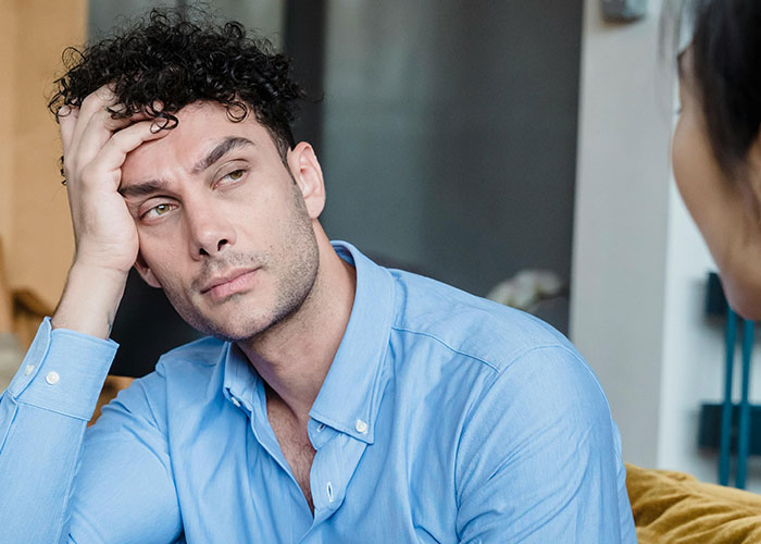 Man in a blue shirt looking frustrated during a serious conversation revealing the moment his ex showed their true self.