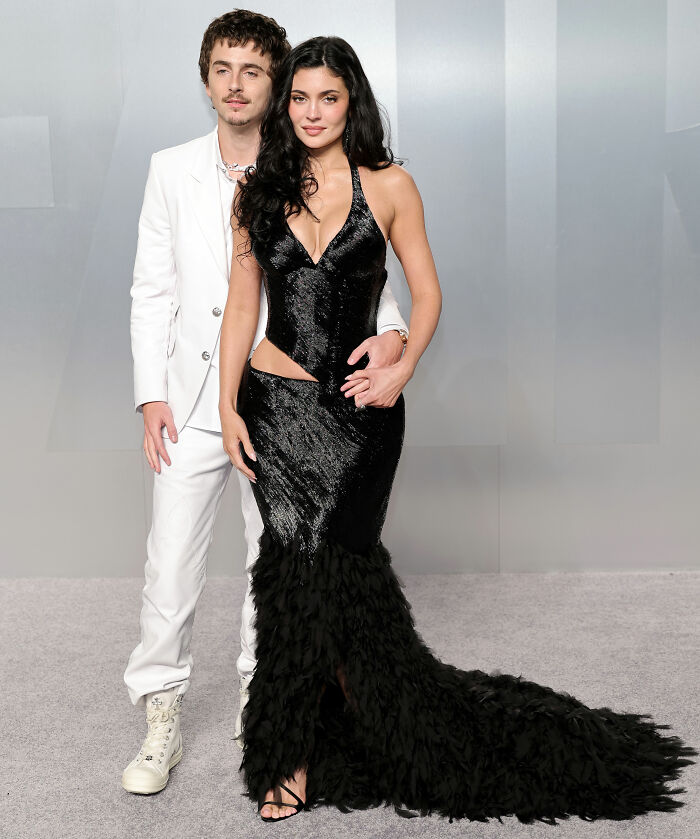 Couple posing on award season red carpet, showcasing bold and unhinged fashion looks and notable fashion fails.