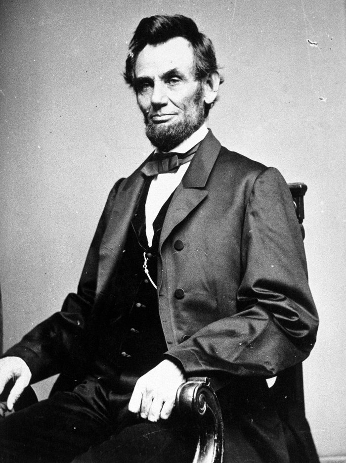 Black and white portrait of a Abraham Lincoln seated, representing influential leaders who changed history.
