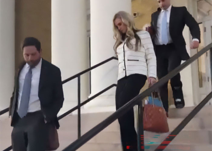 Former Mayor Misty Roberts walking down courthouse stairs with two men, spotlight on religious symbols in the background.