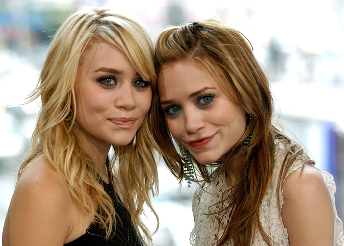 Mary-Kate and Ashley Olsen smiling together at an event, highlighting their disappearance and fan reactions.