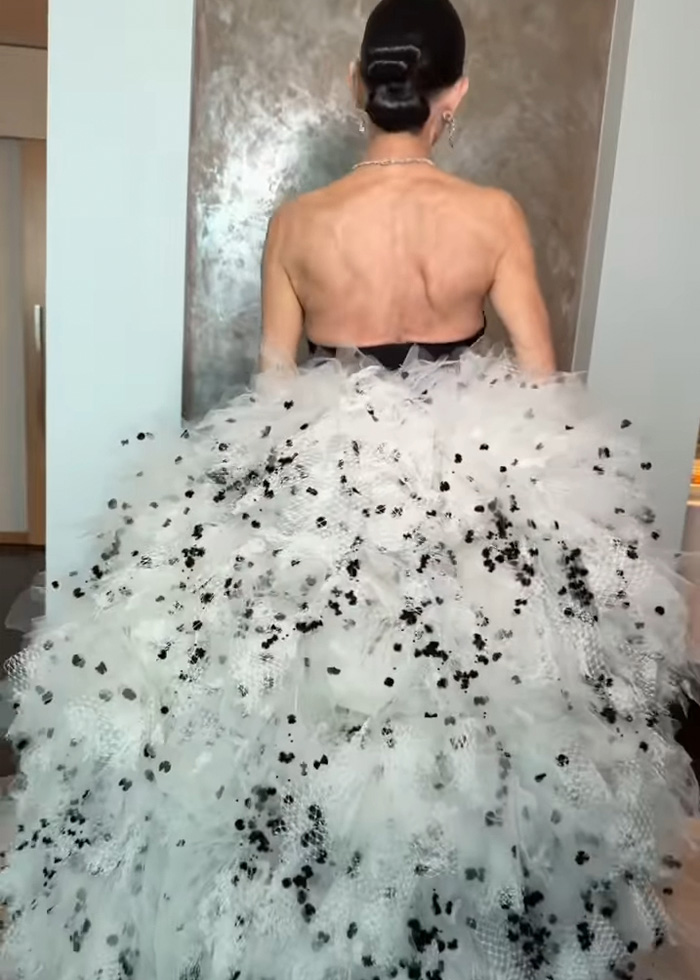 Back view of Demi Moore in a voluminous white and black detailed gown with an updo hairstyle, highlighting a scary Oscars look.