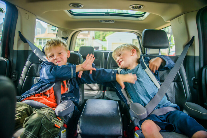 Two young siblings playfully fighting in the backseat of a car illustrating adult sibling rivalry dynamics. Two young siblings playfully fighting in the backseat of a car illustrating adult sibling rivalry dynamics.