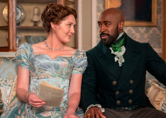 Bridgerton&rsquo;s Ruth Gemmell sitting in period costume with co-star during an intimate filming sequence on set.