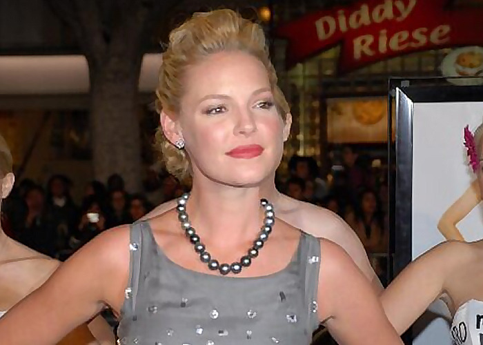 Blonde woman in a grey dress and pearl necklace at a public event, representing celebrities who turned out to be raging jerks.