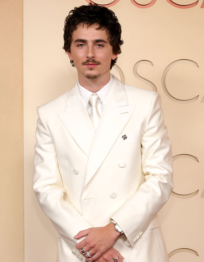 Timothée Chalamet in a white suit at the Oscars 2026, related to Conan O’Brien backlash over awkward b*m drum joke. Timothée Chalamet in a white suit at the Oscars 2026, related to Conan O’Brien backlash over awkward b*m drum joke.