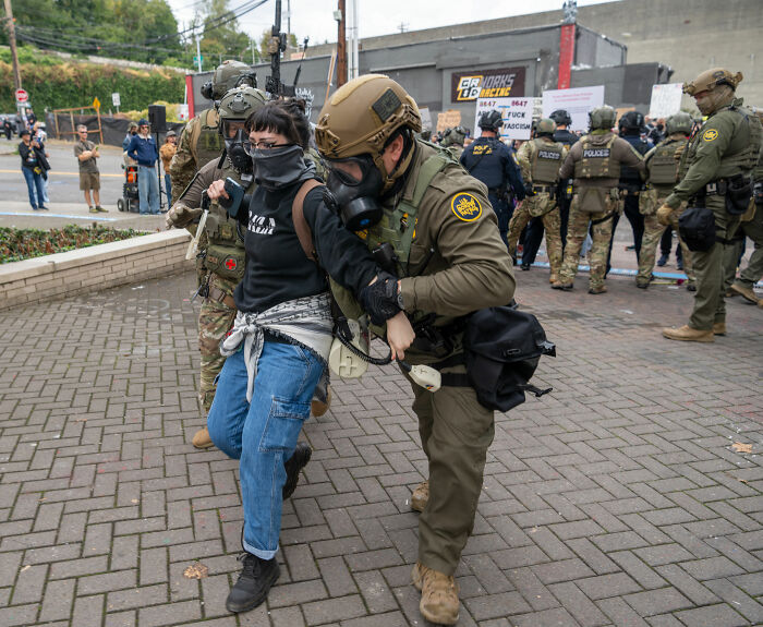Police detain protester during demonstration as White House issues a strong response on diversity controversies.