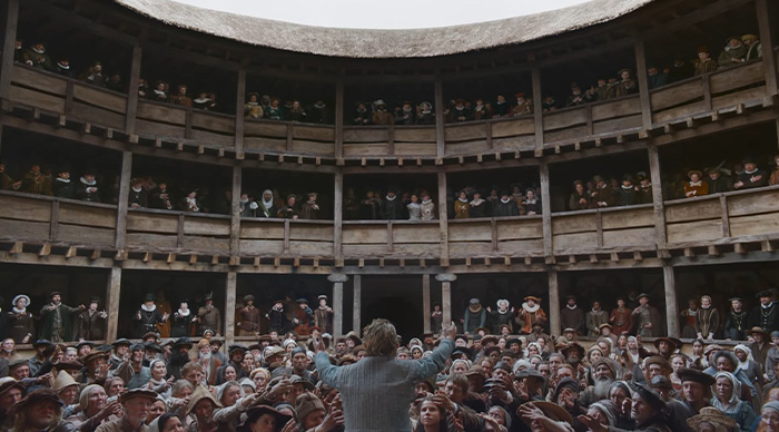 Crowd scene in a historical theater with a central figure addressing the audience, inspired by 2026 Oscar predictions trends.