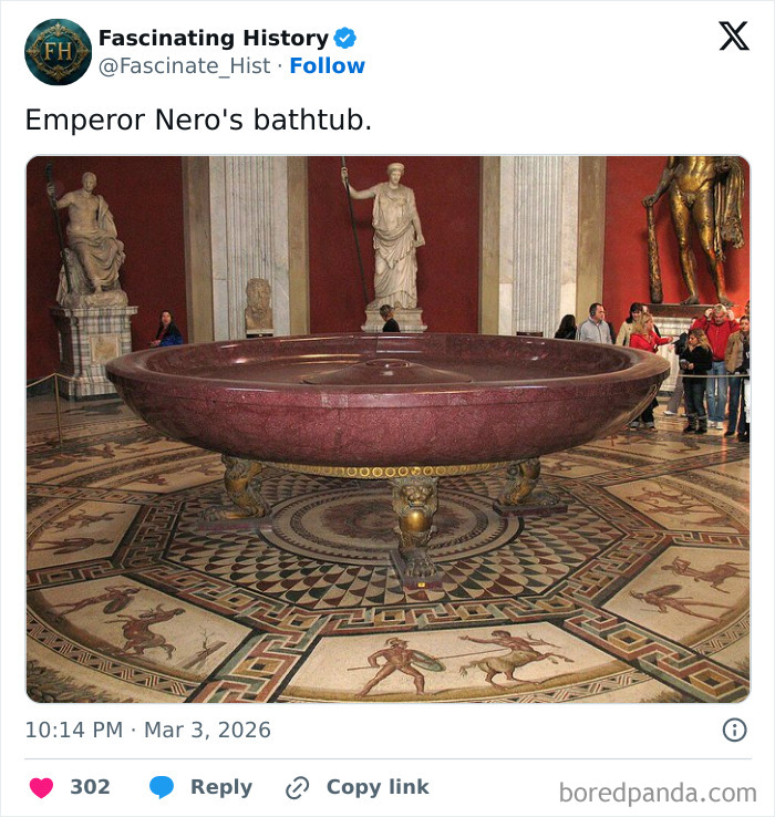Large ancient marble bathtub in a historic museum surrounded by statues and intricate floor mosaics showing advanced historical treasures.