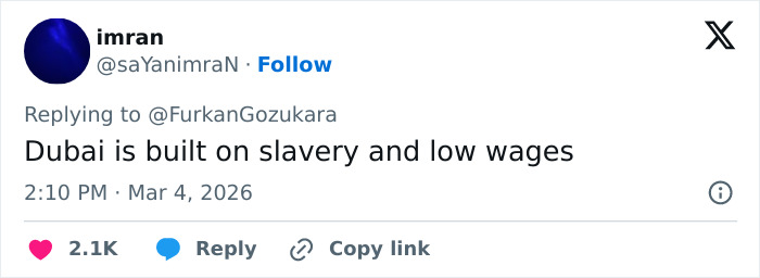 Tweet text showing a user exposing the harsh reality of Dubai's labor camps with claims of slavery and low wages.