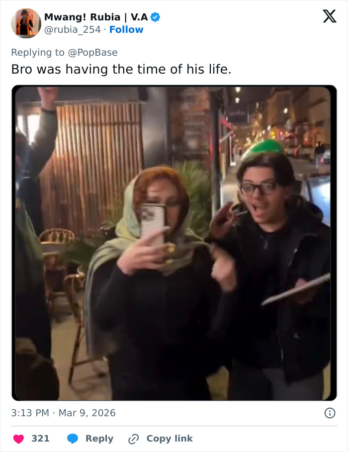 Person holding phone takes selfie with friend at night outside, capturing moment while trying so hard to be like Lady Gaga.
