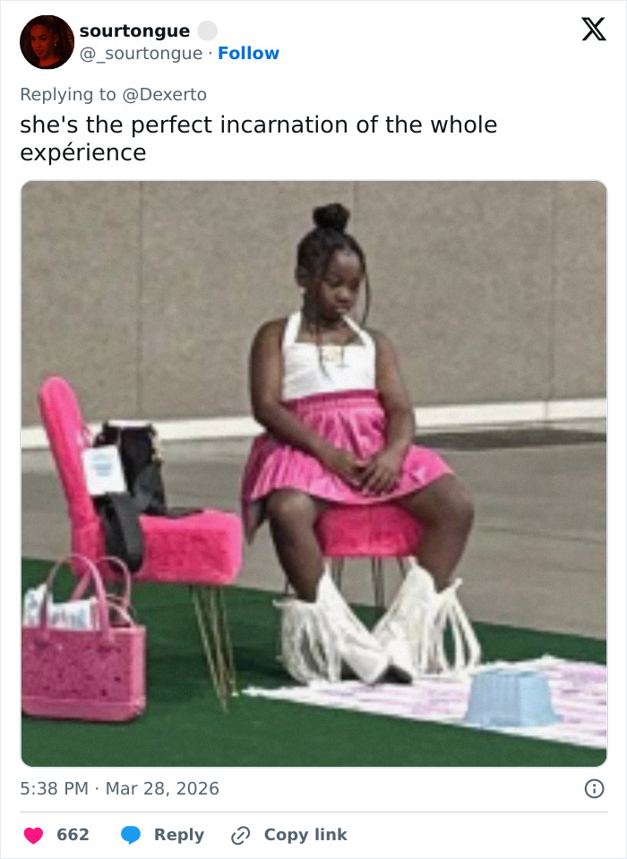 Young girl in pink dress and white fringe boots sitting on a chair at Barbie Dream Fest experience event.