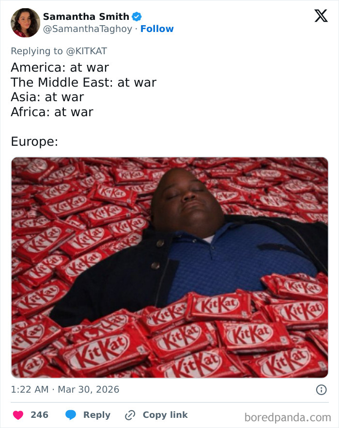 Person lying surrounded by numerous KitKat bars, illustrating humorous reactions to 12 tons of KitKat stolen.