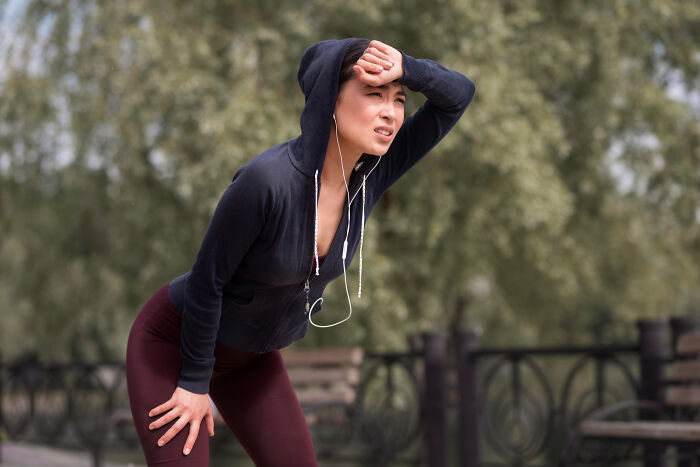 Woman in workout clothes looking tired and frustrated outdoors, representing common struggles women face.