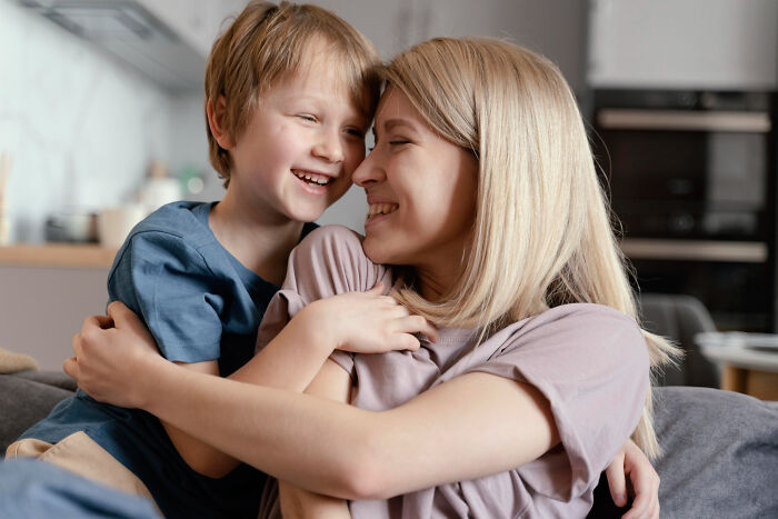 Mother and son sharing a tender moment in a cozy living room, reflecting tough reasons for staying in a relationship.