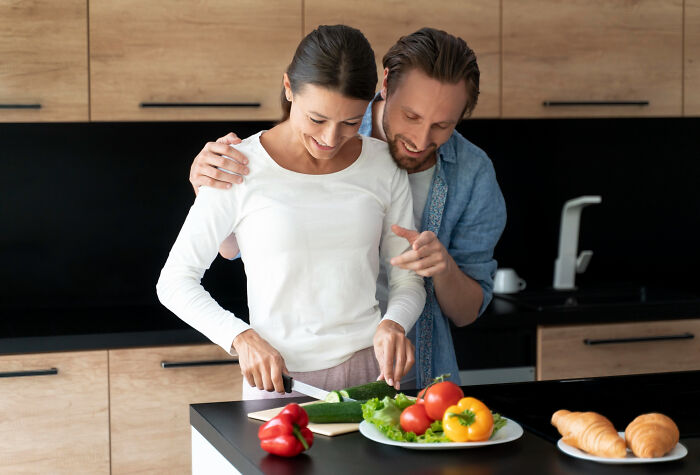 Couple preparing fresh vegetables together in kitchen, highlighting common women experiences not part of being a woman.