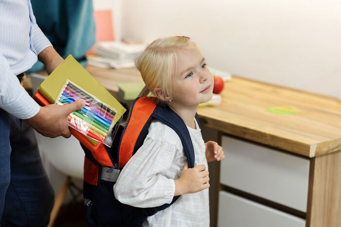 A child with a backpack being packed by an adult, illustrating tough reasons why people stay in relationships.