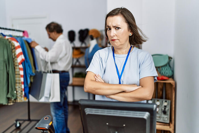 Woman giving a skeptical stare in a retail store while a man shops, illustrating reactions to the Gen Z stare.