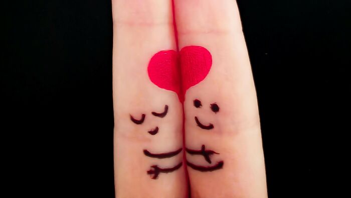 Two fingers painted with faces and arms hugging, forming a heart, illustrating things everyone thought were unique as a kid