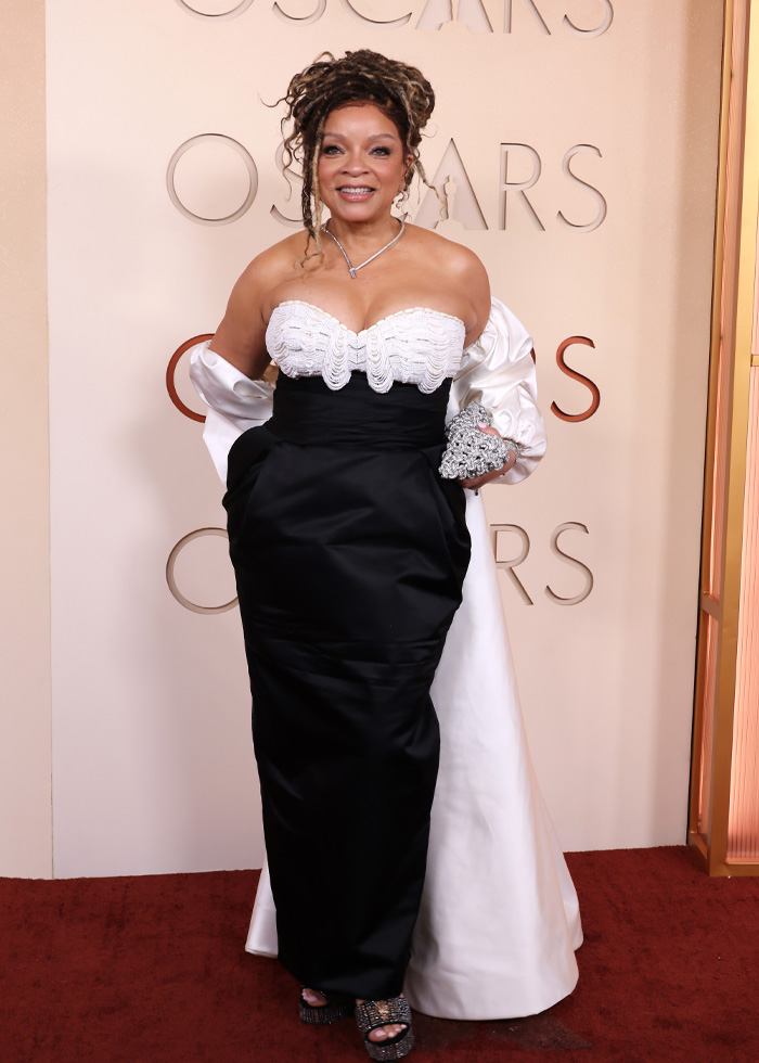 Elegant woman in a black and white gown posing on the red carpet showcasing jaw-dropping outfits from Oscars 2026 event.