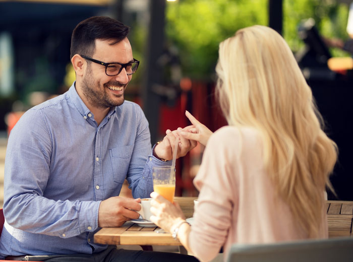 Man holding woman&rsquo;s hand at a caf&eacute;, symbolizing deep regret after ditching fianc&eacute;e to chase the one that got away.