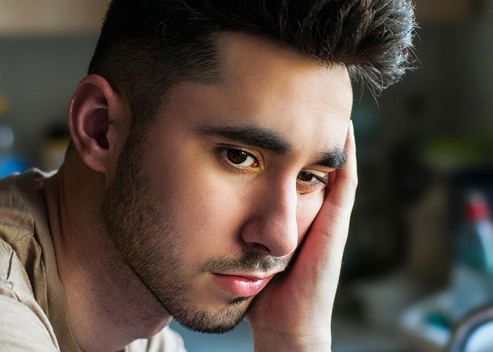 Young man looking thoughtful and sad, reflecting on the moment his ex revealed who they really were after divorce.