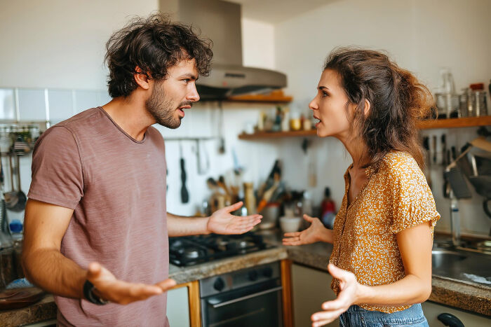 A young man and woman having a tense conversation in a kitchen illustrating women secrets men don’t know.