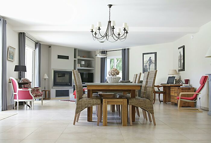 Spacious dining room with wicker chairs, wooden table, and fireplace, inviting reflection on ethical and moral dilemmas.