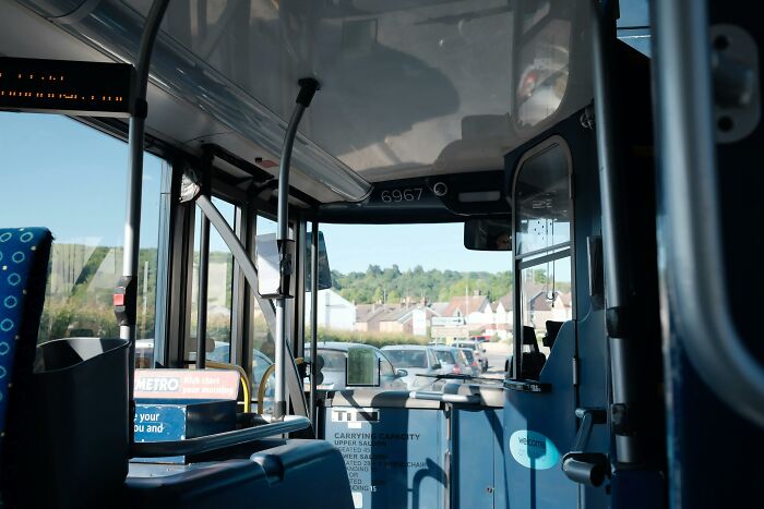 Interior view of a bus with empty seats and a glimpse of traffic outside, illustrating an ethical and moral dilemmas setting.