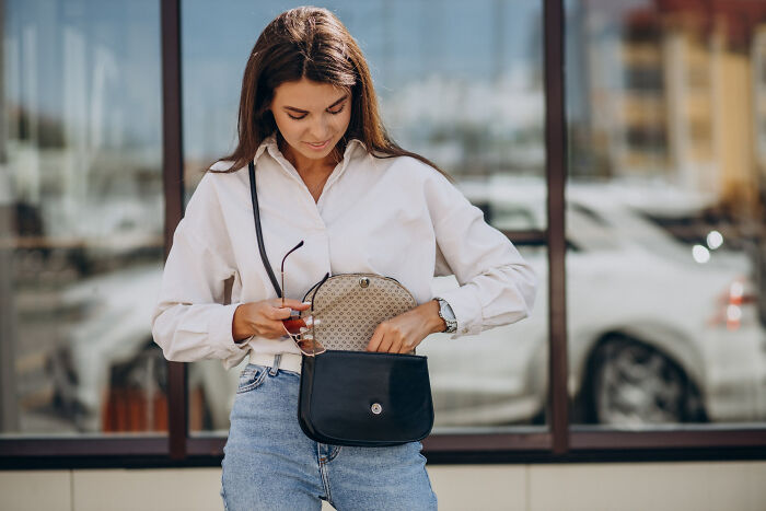 Woman wearing casual outfit checking her purse, illustrating period wardrobe and women’s personal secrets concept.