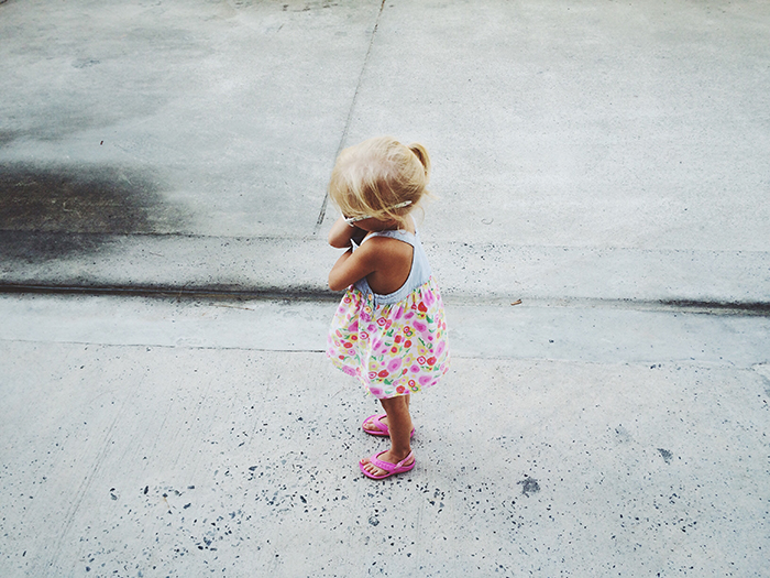 Young child in colorful dress standing alone on a concrete surface, symbolizing single man's life changes after child services call. Young child in colorful dress standing alone on a concrete surface, symbolizing single man's life changes after child services call.