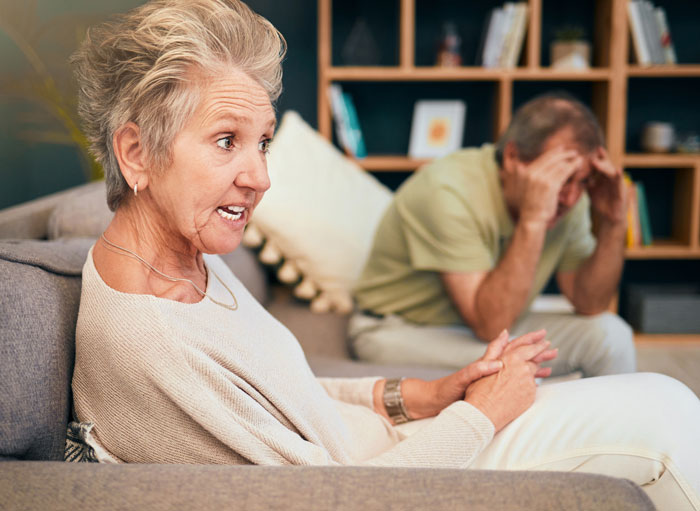 Casal mais velho tendo uma conversa tensa na sala de estar, ilustrando o conflito familiar entre babás e os verdadeiros sentimentos dos avós. Casal mais velho tendo uma conversa tensa na sala de estar, ilustrando o conflito familiar entre babás e os verdadeiros sentimentos dos avós.