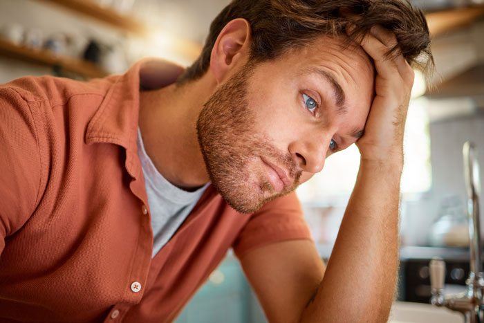 Man looking worried and stressed at home, reflecting feelings of a guy complaining about his wife and family concerns.