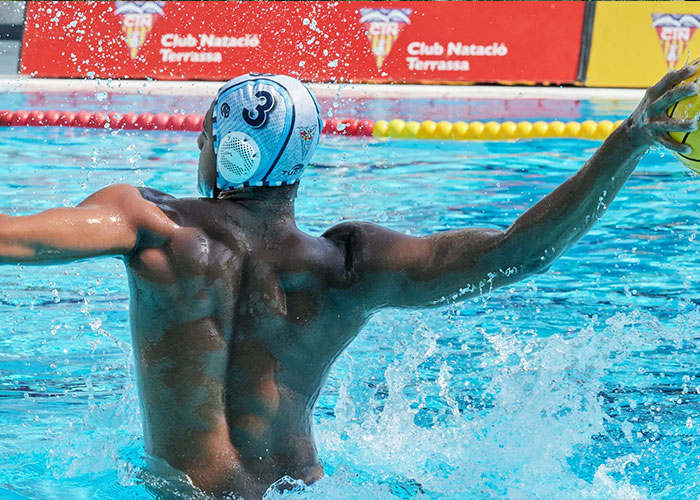 Star water polo player in action, raising arm to throw ball in pool during intense underwater team match. Star water polo player in action, raising arm to throw ball in pool during intense underwater team match.