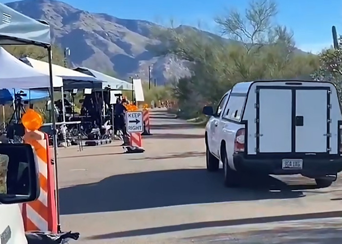 White vehicle parked near a Phoenix canal with equipment and personnel related to the Nancy Guthrie case investigation