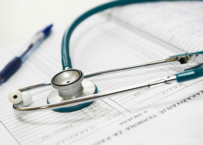 Stethoscope and pen on medical documents, symbolizing dark medical secrets and hidden healthcare truths.