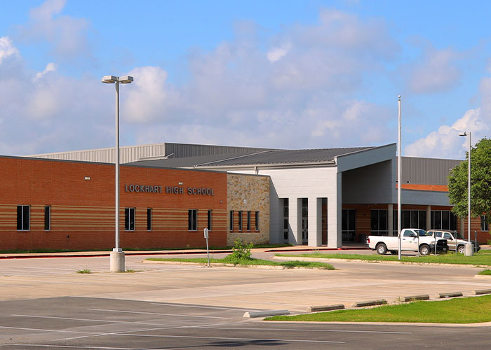 Lockhart High School building under a partly cloudy sky, related to teacher viral mugshot student scandal update.