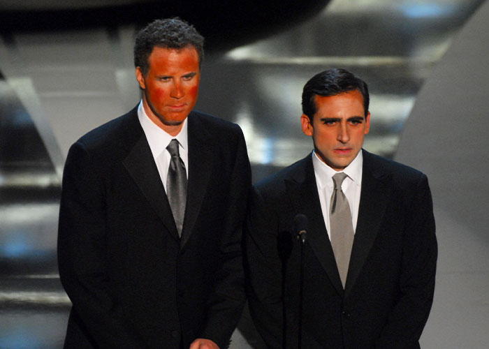 Two men in black suits on stage at the Oscars, representing awkward celebrity moments in Oscars history.