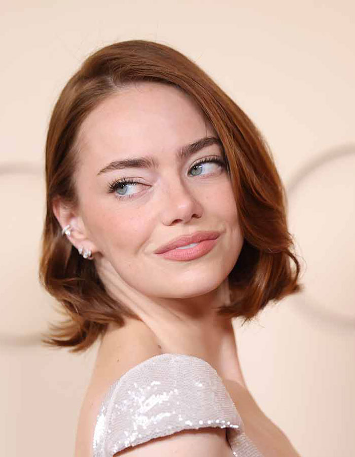 O visual do Oscar de Emma Stone levanta as sobrancelhas enquanto a conversa sobre as normas de beleza 'Hollyweird' se intensifica
